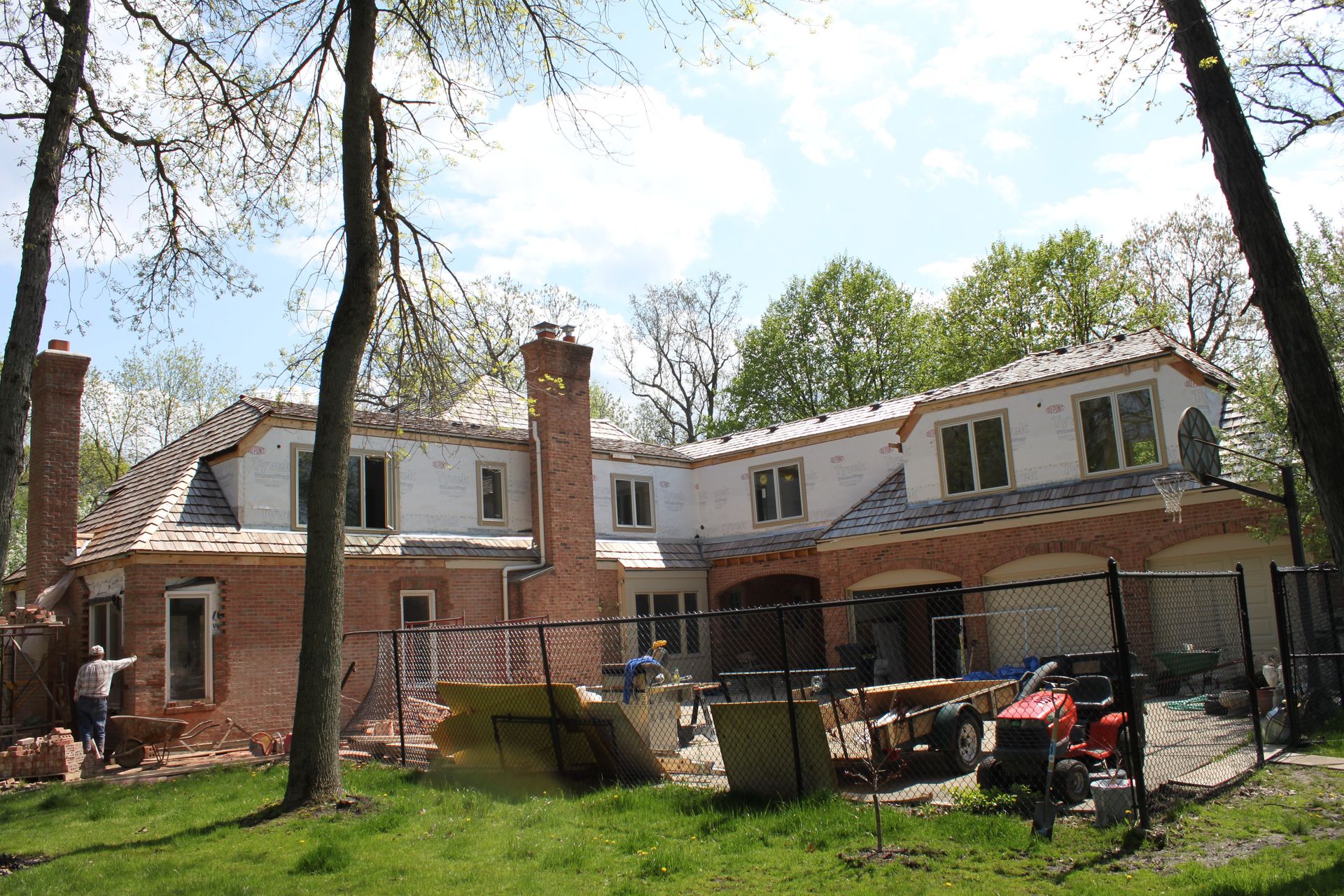 A large brick house is being built in the middle of a forest.