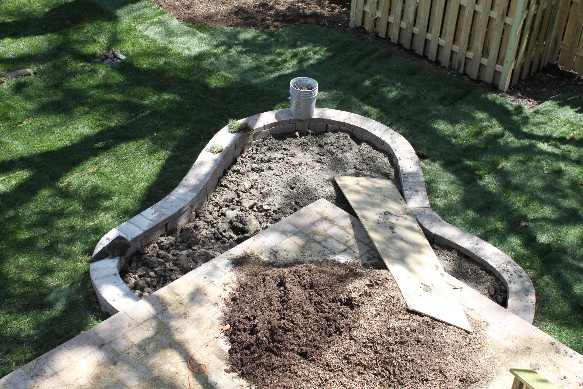 A pile of dirt is sitting on top of a concrete surface in a yard.
