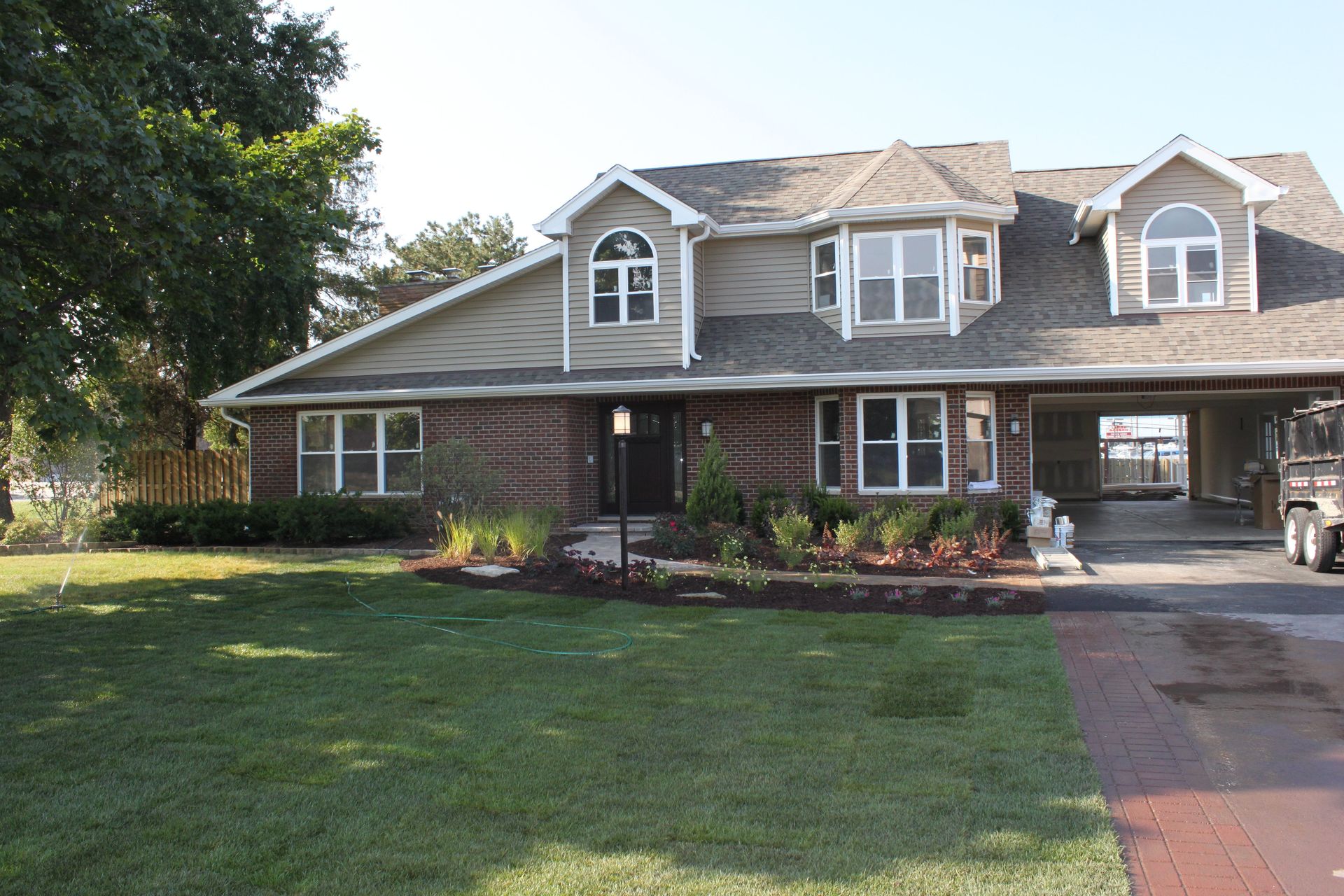 A large brick house with a car parked in front of it