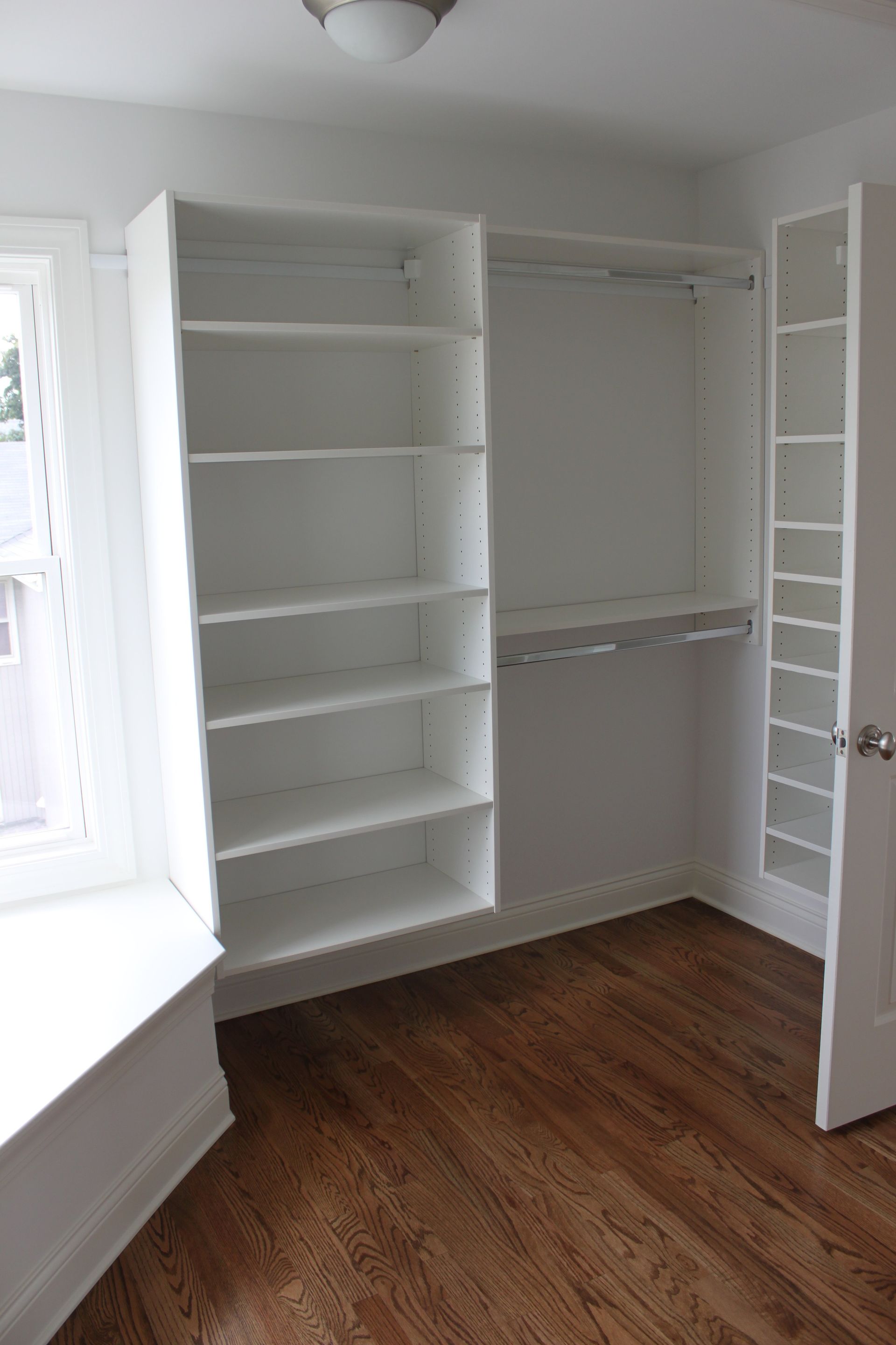 A closet with lots of shelves and a window.