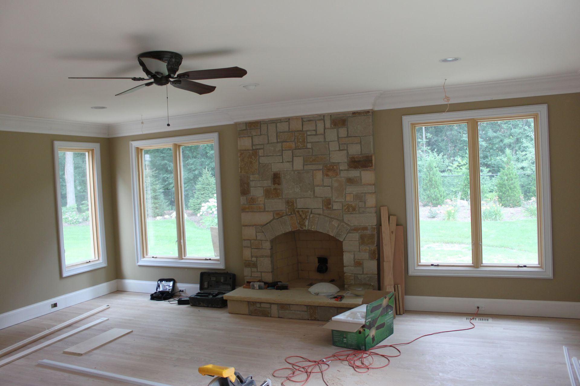 A living room with a fireplace and a ceiling fan