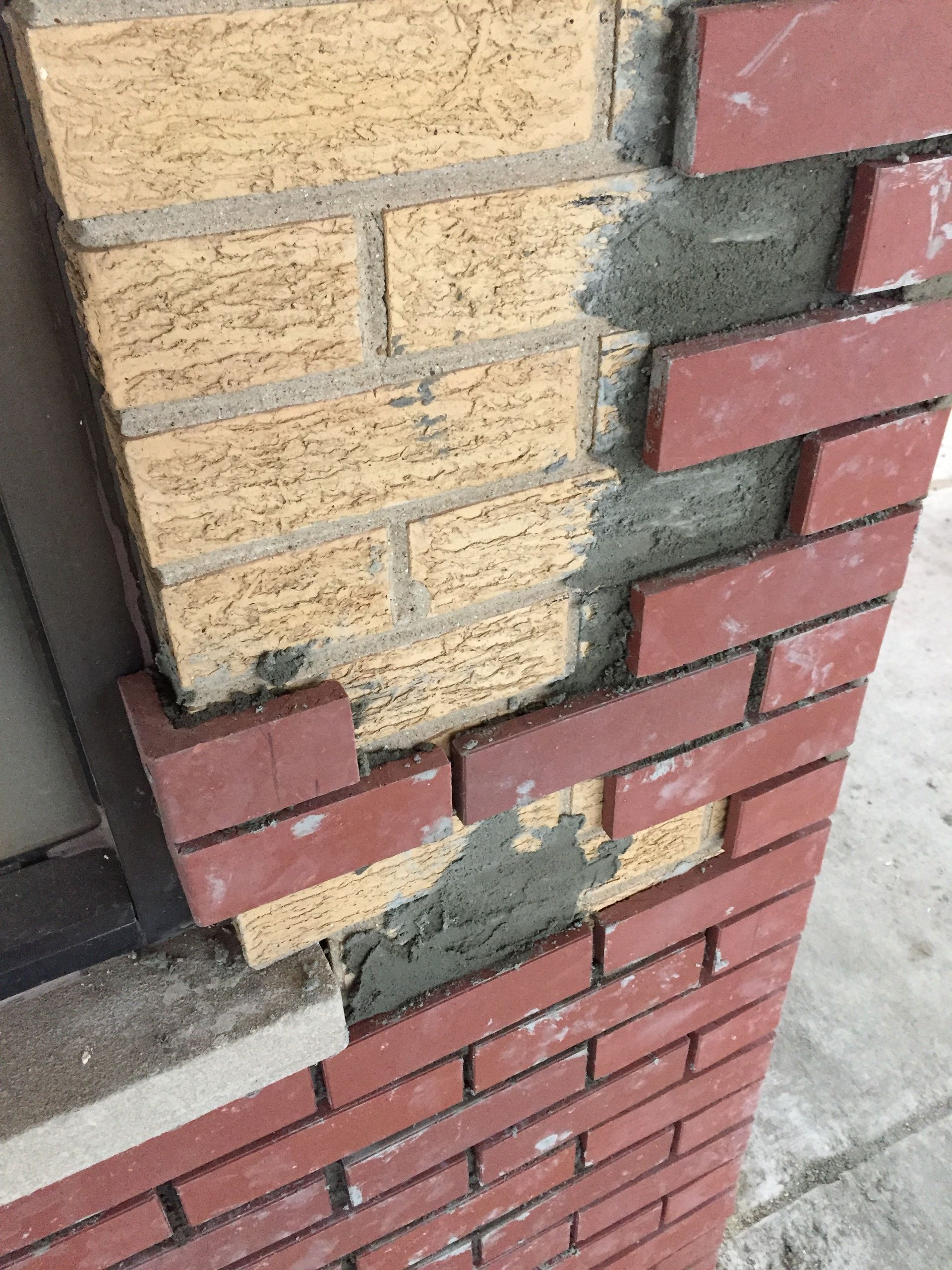A close up of a brick wall with bricks missing.