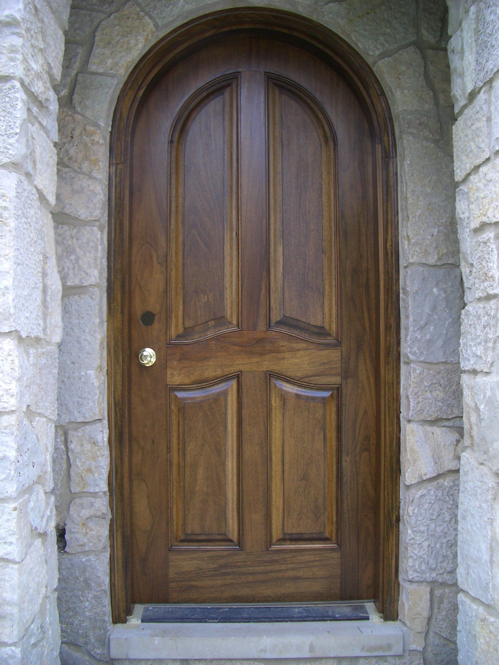 A wooden door with a stone wall behind it