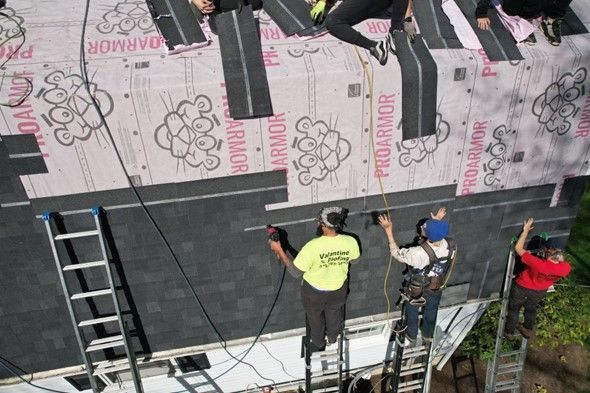 A group of people are working on a roof that says pro armor