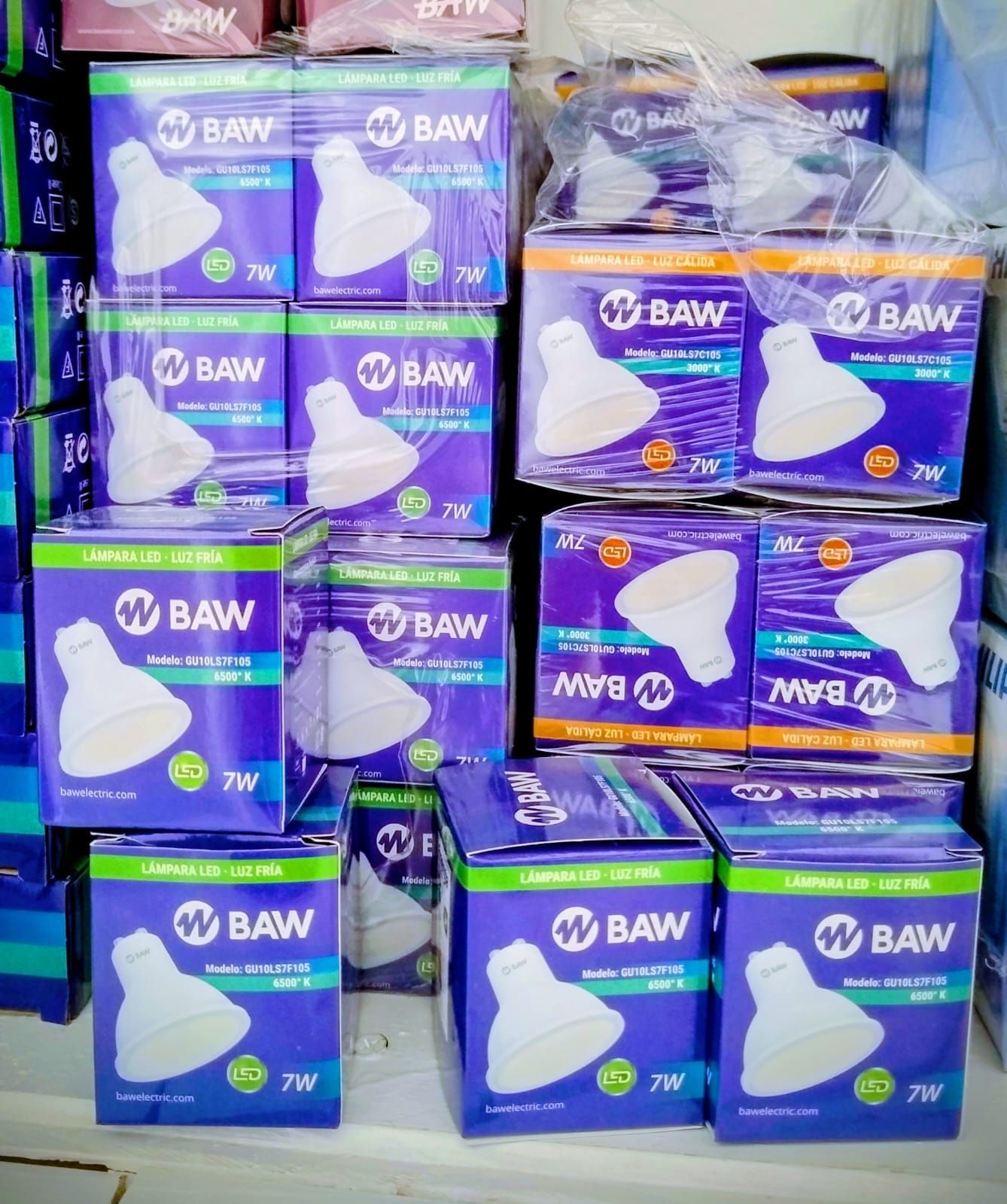 Cajas de bombillas BAW de 7W, en un entorno comercial. Las cajas son moradas con logotipos blancos.