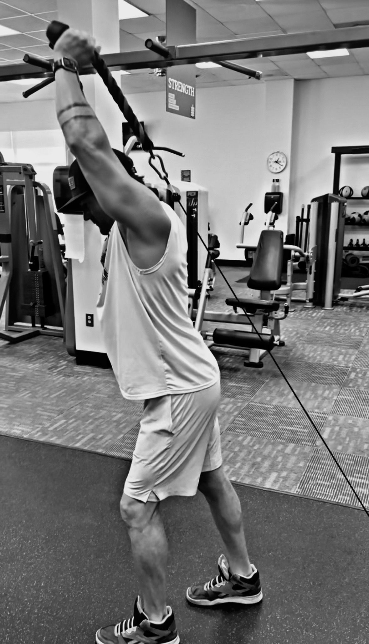 A man is doing exercises on a machine in a gym.