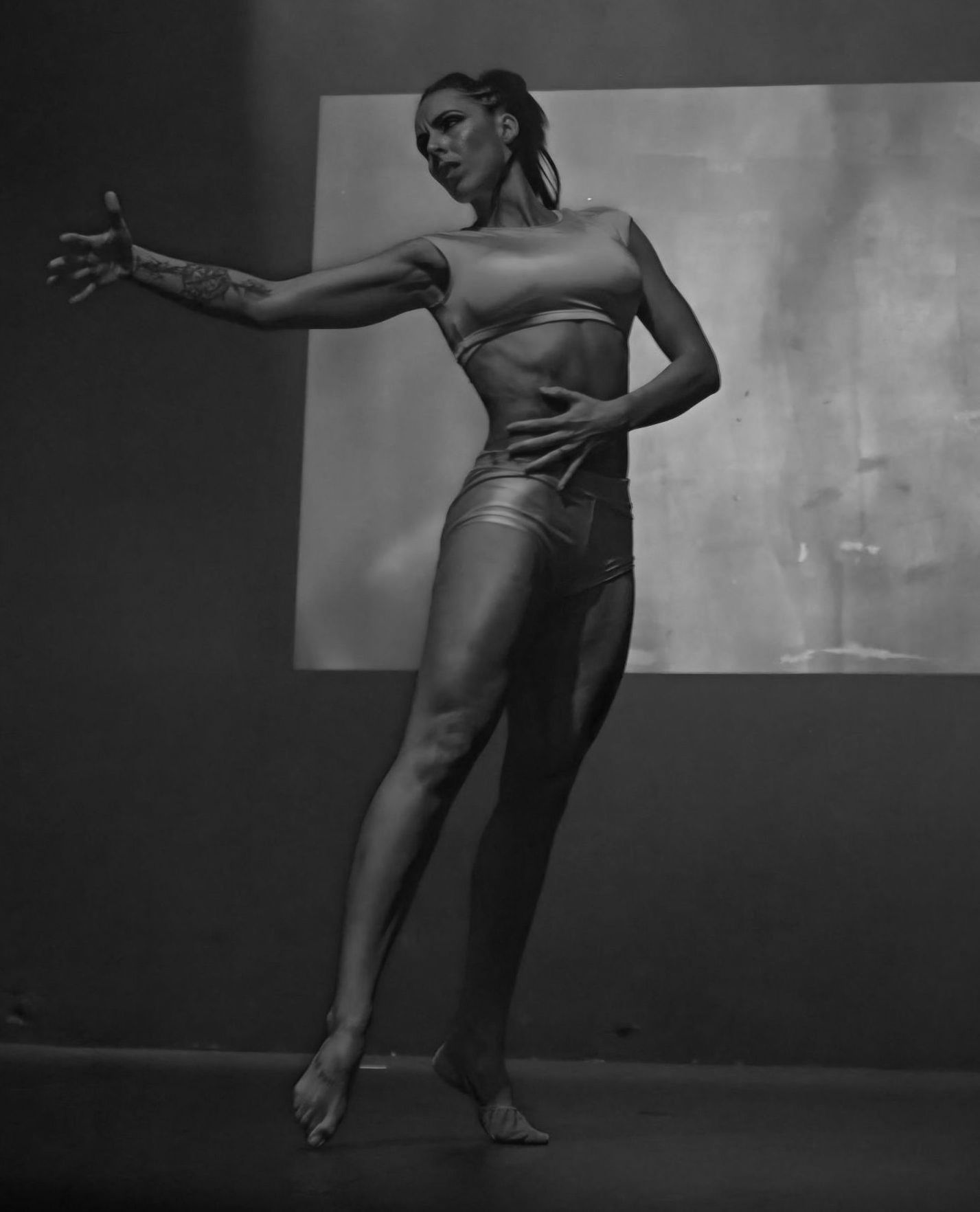 A black and white photo of a woman dancing on a stage.