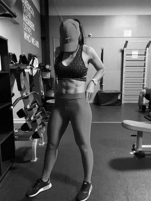 A black and white photo of a woman in a gym