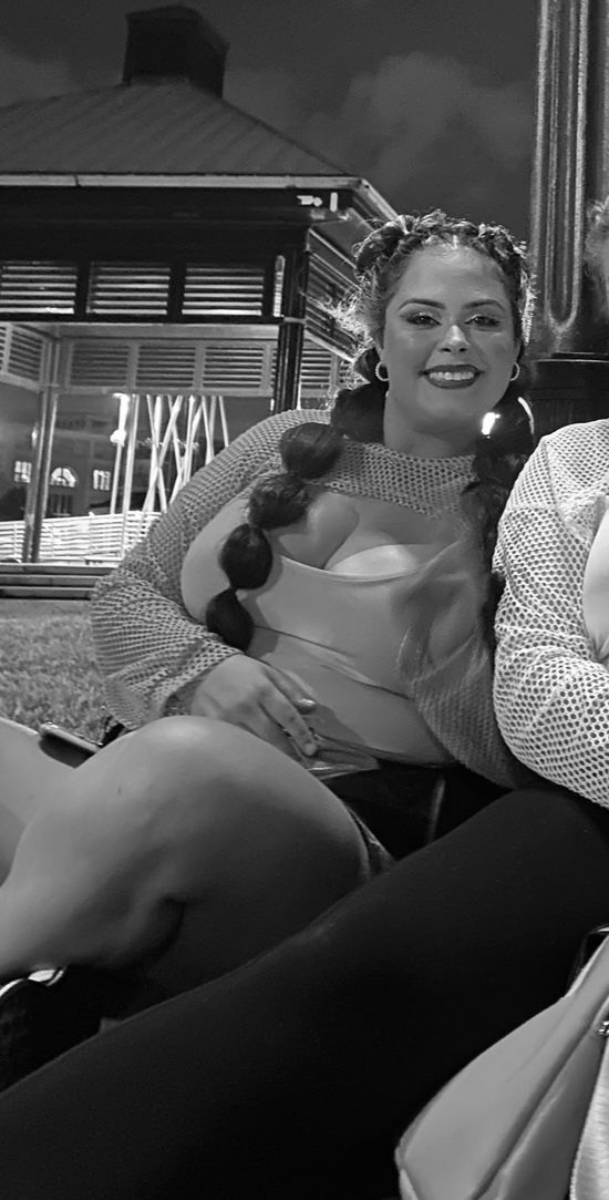 A black and white photo of a woman sitting on a couch.