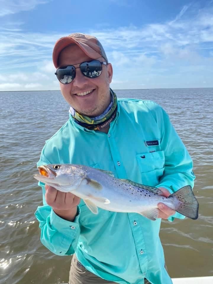 A man is holding a fish in his hands on a boat.