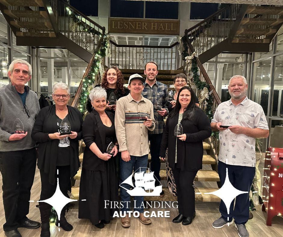 First Landing team posing indoors holding trophies under a Lennner Hall sign.