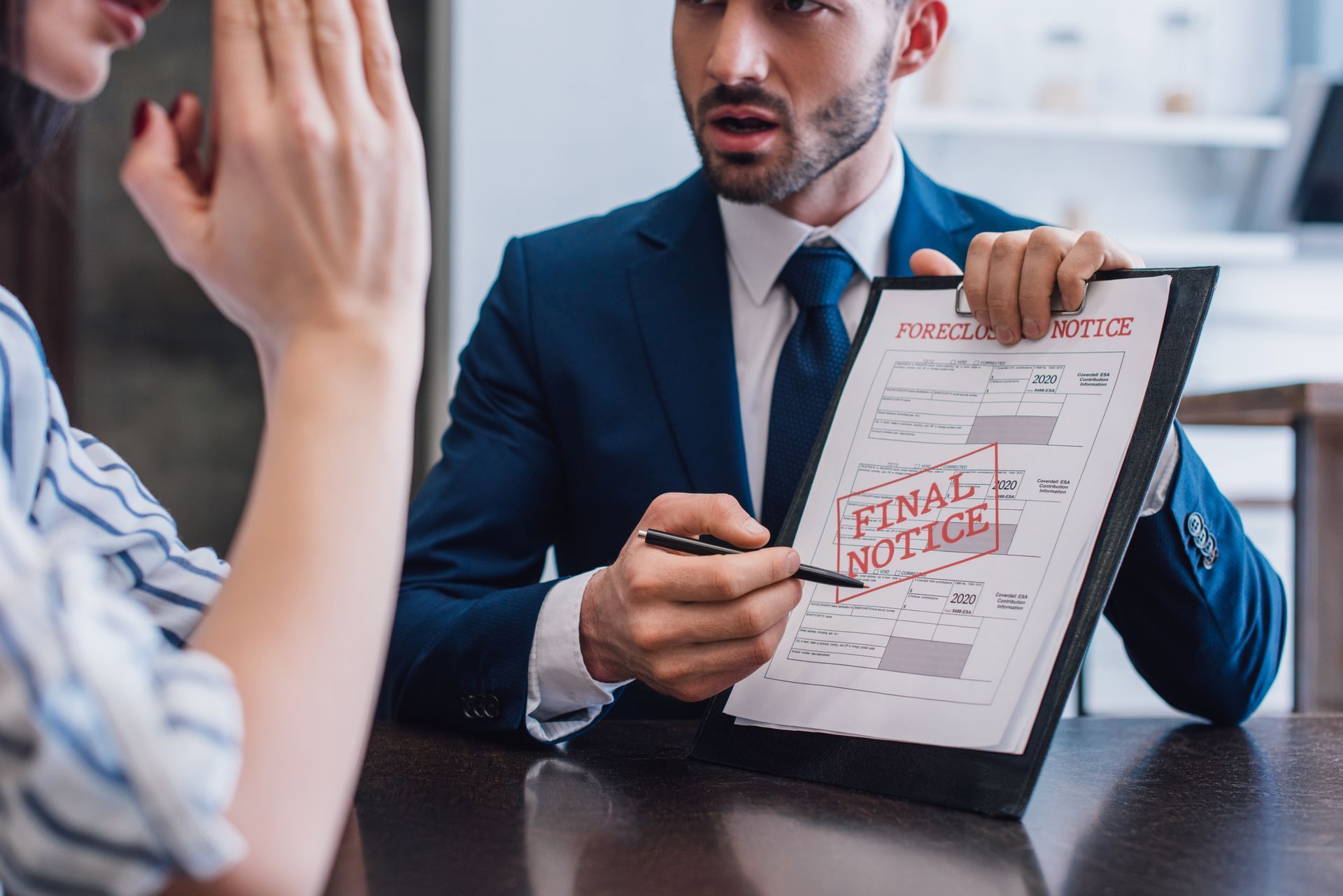 A man in a suit and tie is holding a clipboard with a final notice stamped on it.