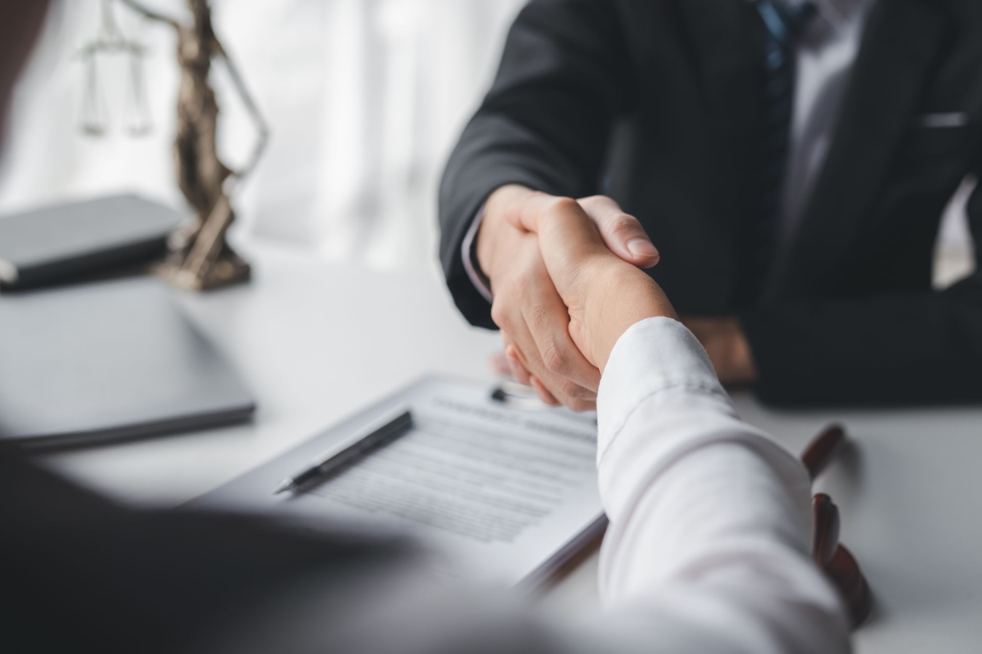 A man in a suit and tie is shaking hands with a woman in a white shirt.