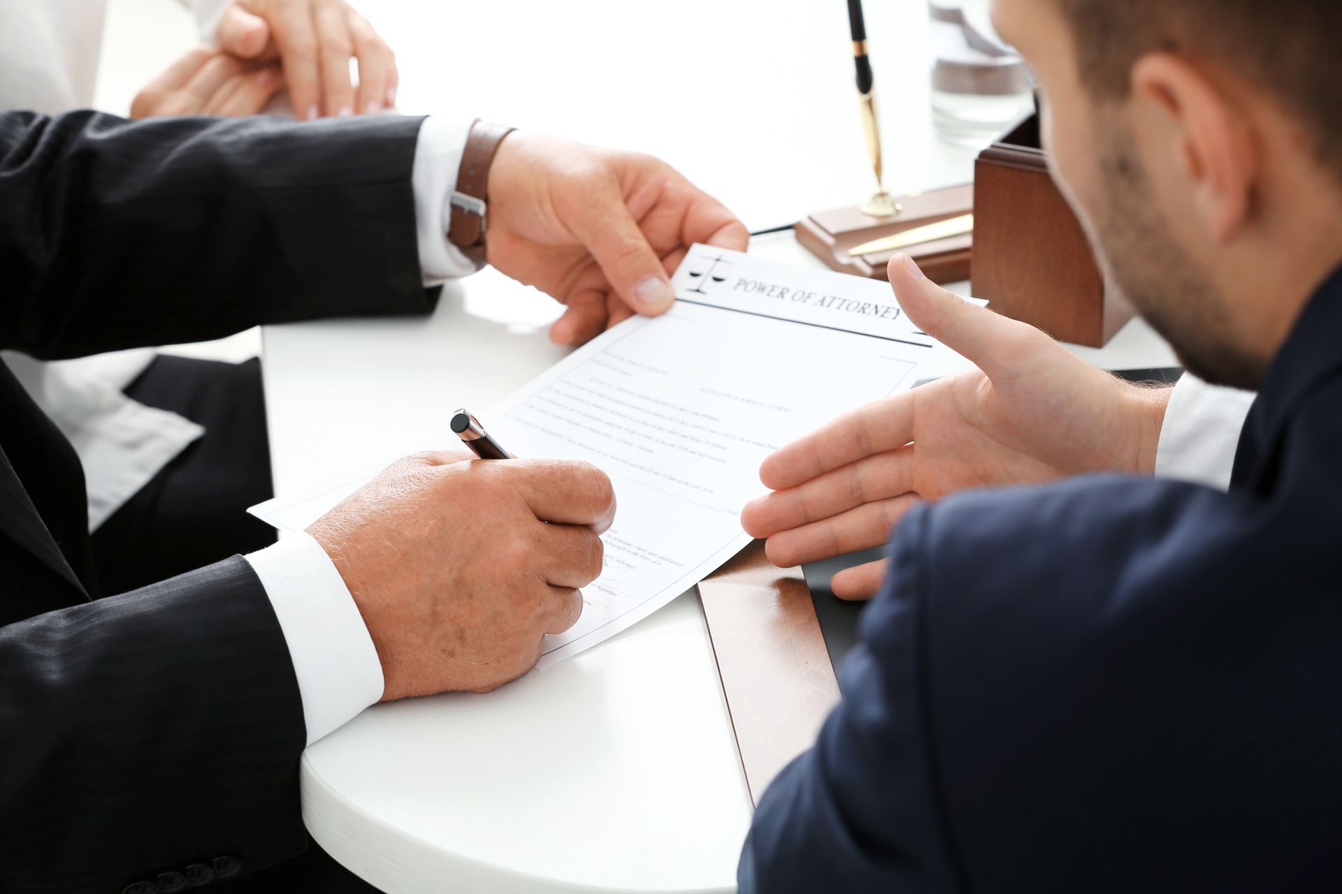 A group of people are sitting at a table signing a document.