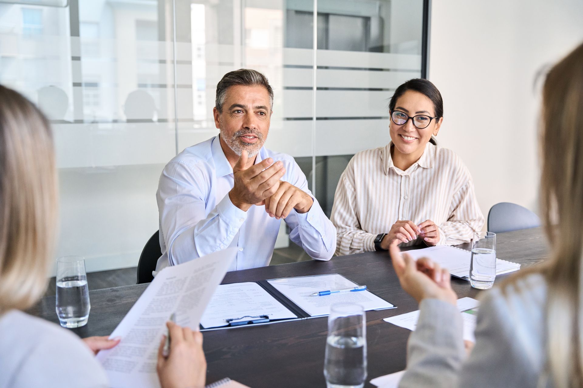 A group of people are sitting around a table having a meeting.