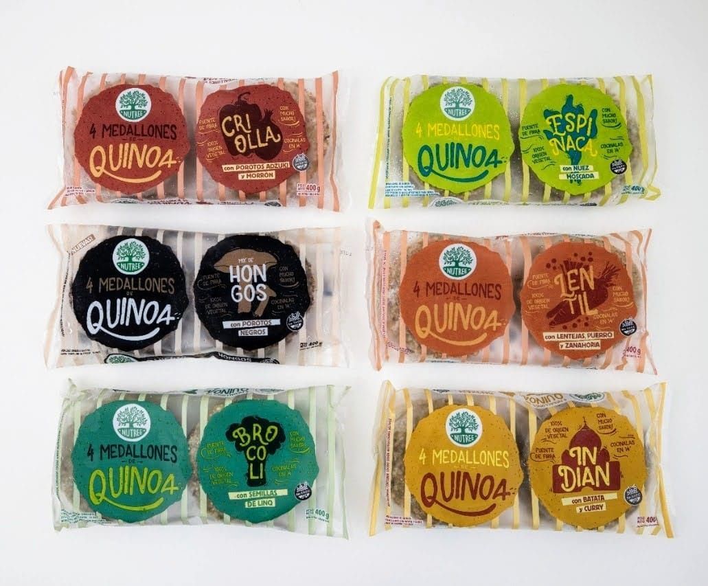 Seis paquetes de hamburguesas de quinoa en diferentes colores y sabores sobre un fondo blanco.