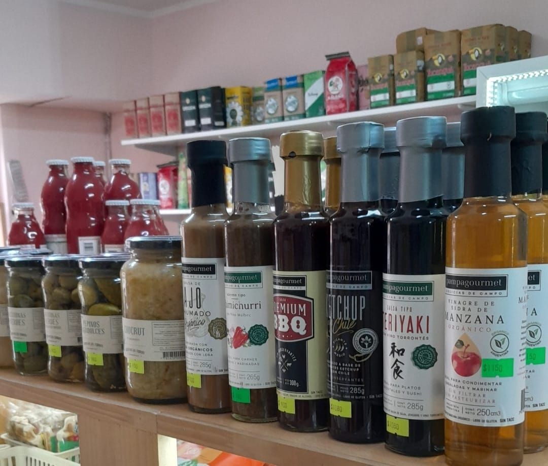 Botellas de salsas, encurtidos y condimentos en los estantes de una tienda.