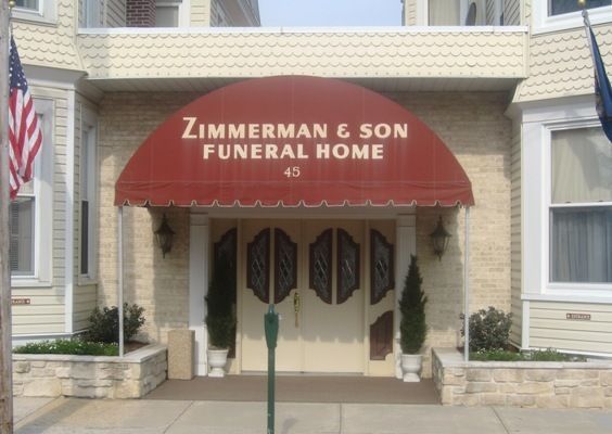 A building with a red awning that says zimmerman & son funeral home