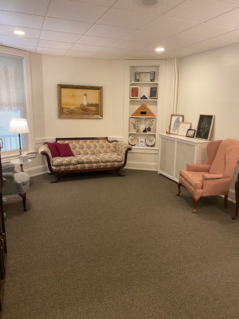 A living room with a couch and two chairs