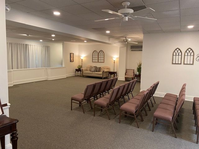 A large room with a lot of chairs and a ceiling fan.