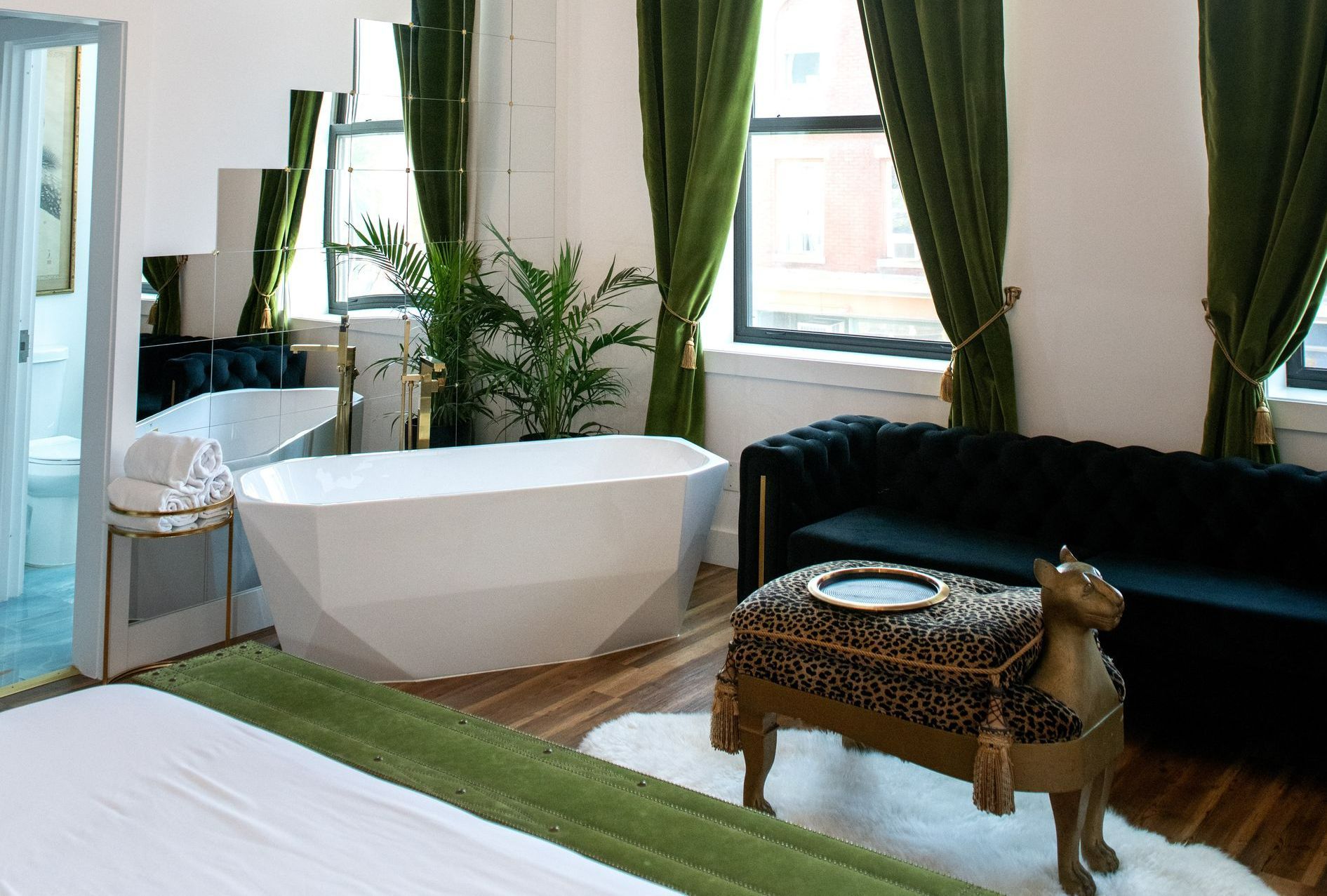 A bedroom with a bathtub and a couch