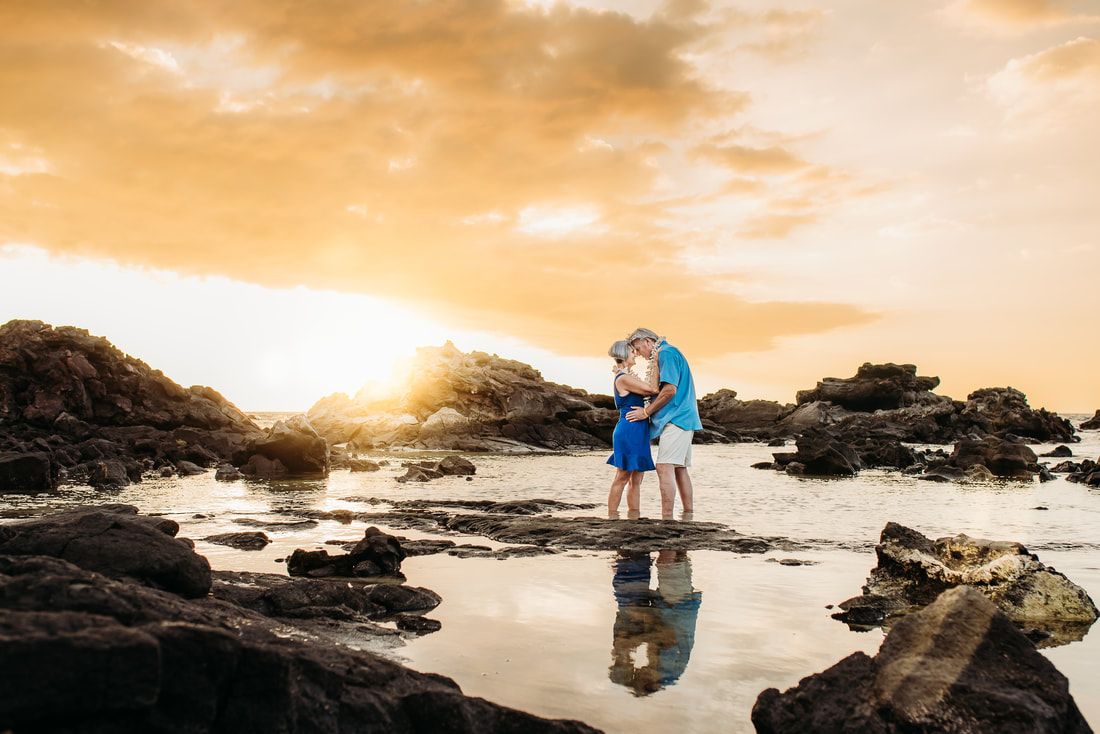 Wedding on beach: groom holds bride's hand, woman raises arms in celebration, ocean in background.