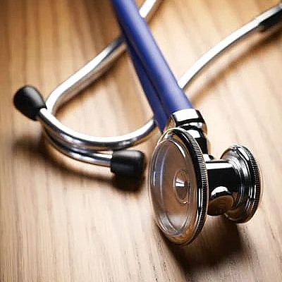A close up of a stethoscope on a wooden table.