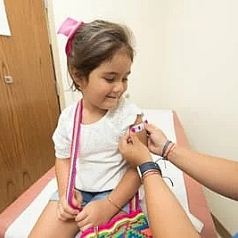 A little girl is getting a vaccine from a doctor.