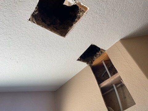Two square holes in the ceiling of a room.