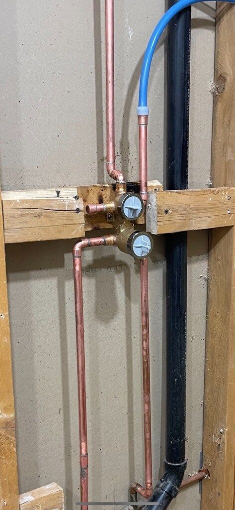 A bunch of pipes are connected to a wall.