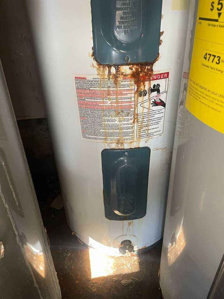 A water heater is sitting in a room next to a refrigerator.