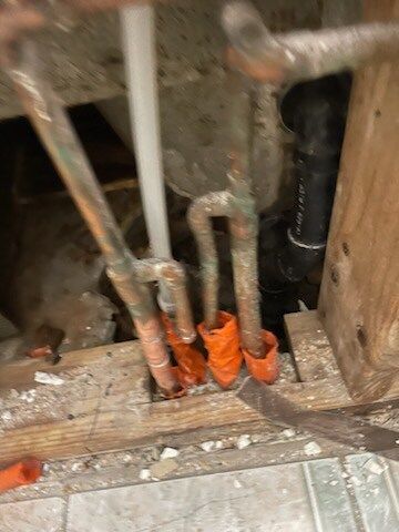 A bunch of pipes are sitting on top of a wooden floor.