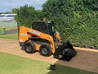 A case skid steer loader is parked in a driveway.