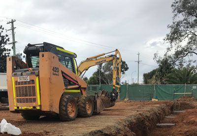 A bulldozer and an excavator are working on a construction site.