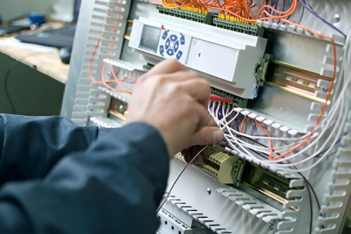 A Person Is Working On A Electrical Box With Wires — GJT Electrical In Lake Macquarie, NSW