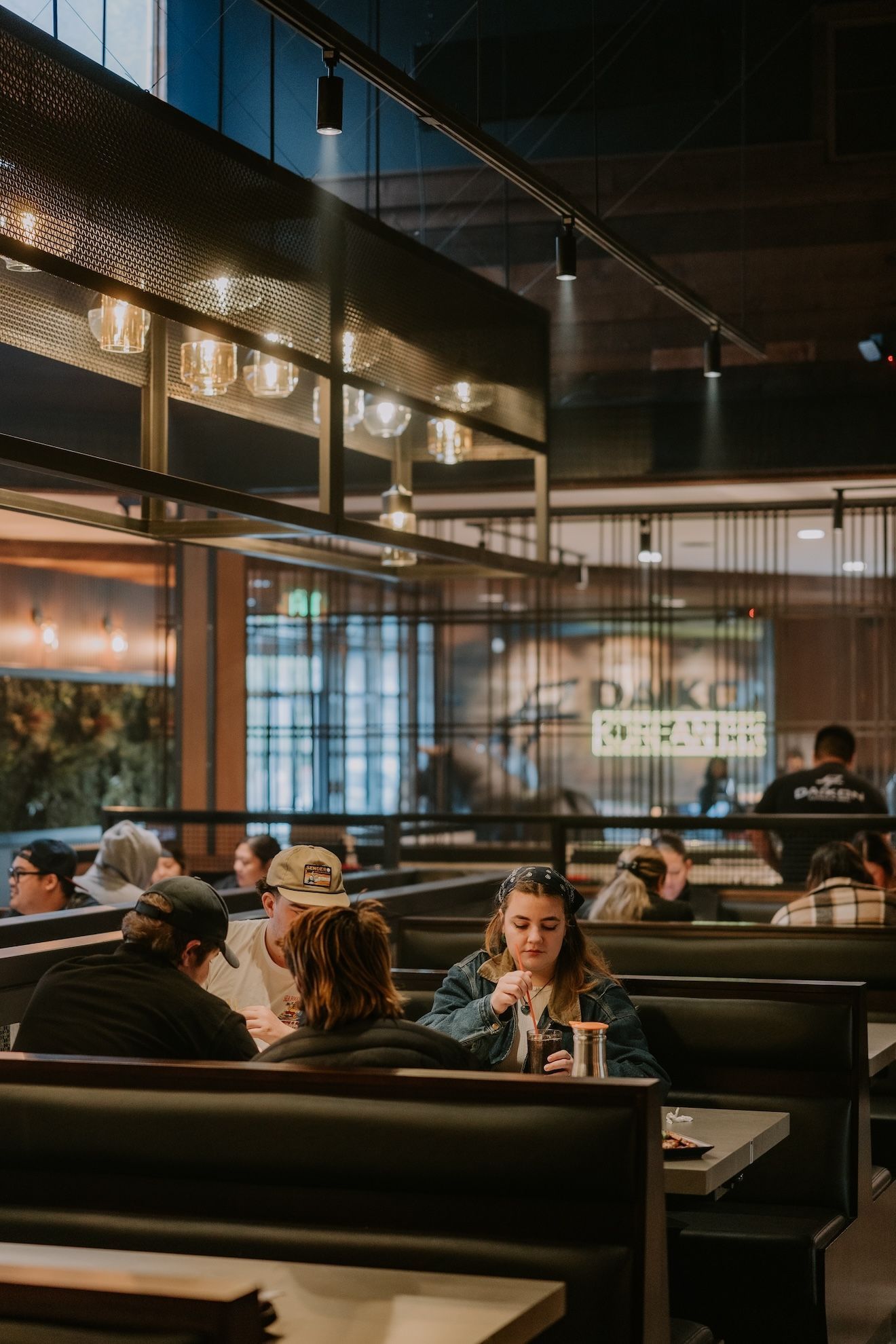 a group of people are sitting at tables in a restaurant .