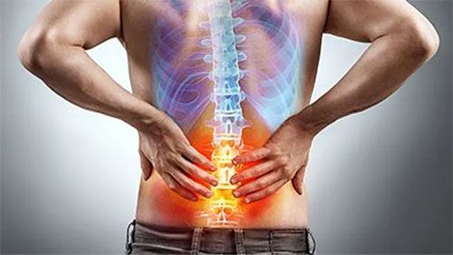 A man is holding his back in pain because of a backache.