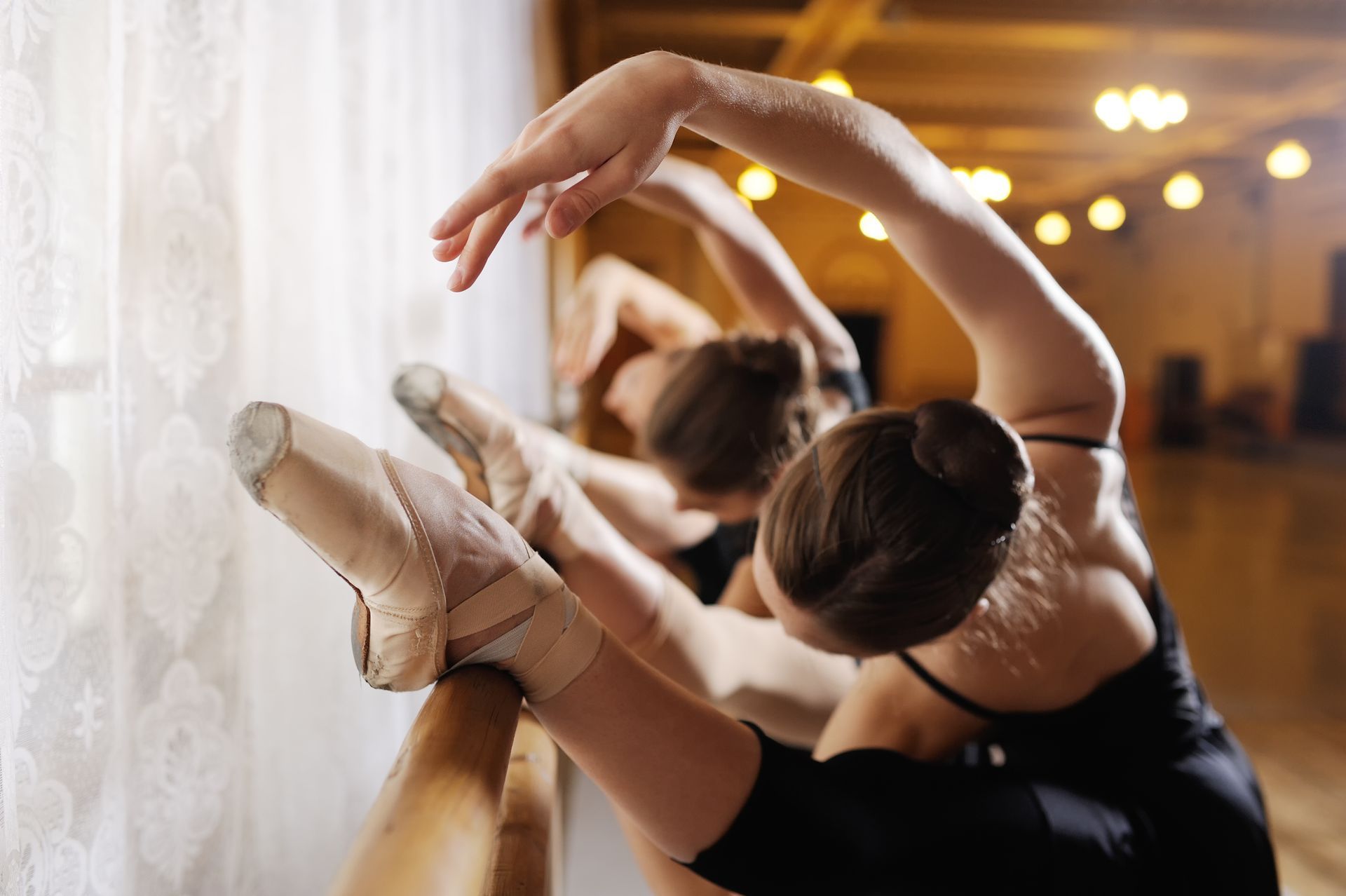 Three ballerinas at a ballet class.