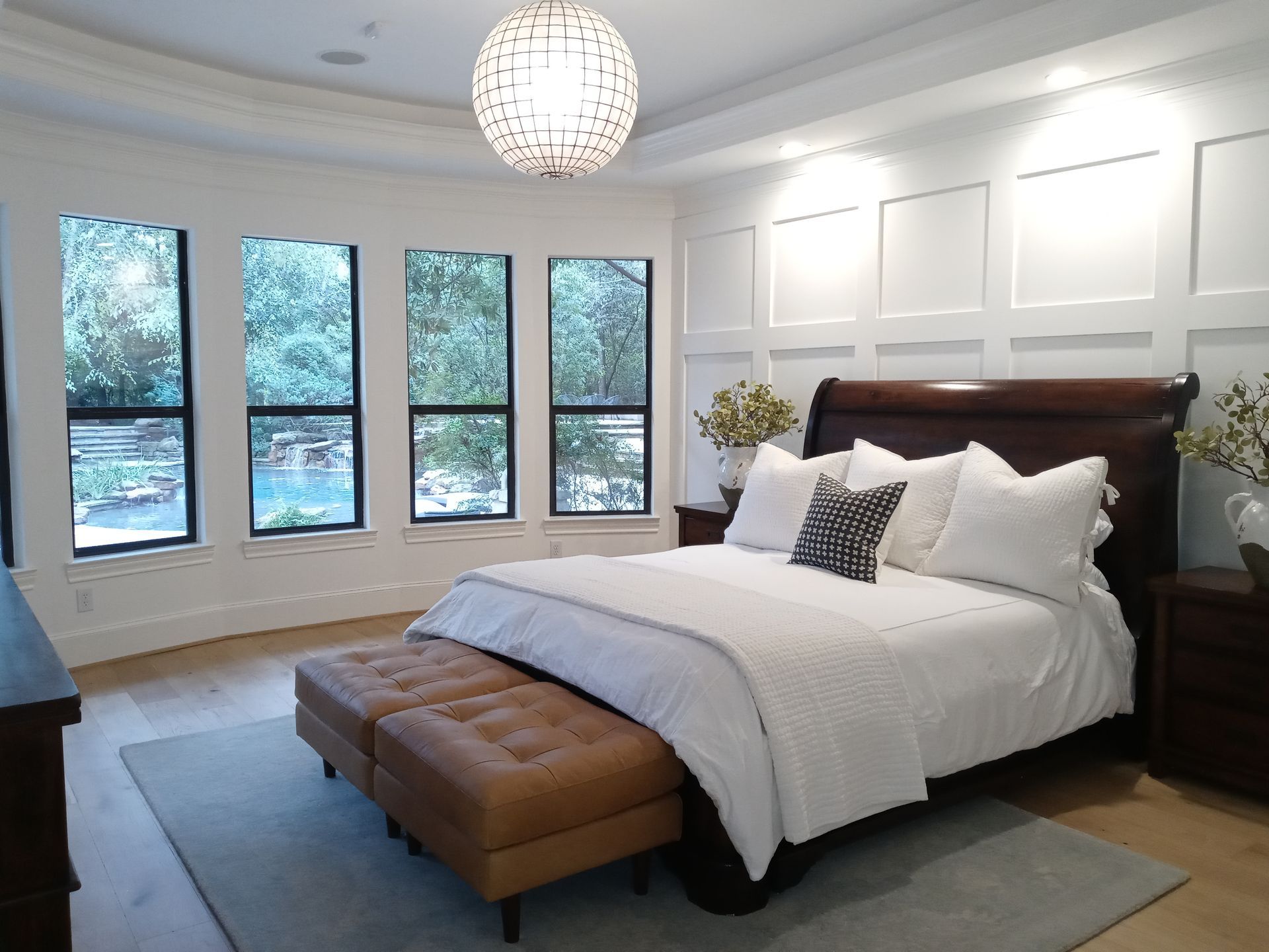 A bedroom with a large bed and lots of windows