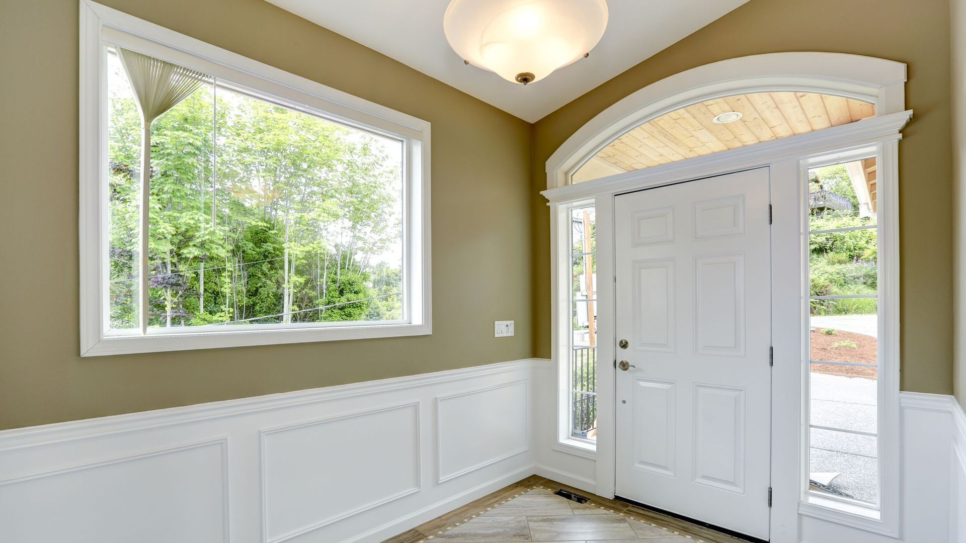 A hallway with a white door and two windows.