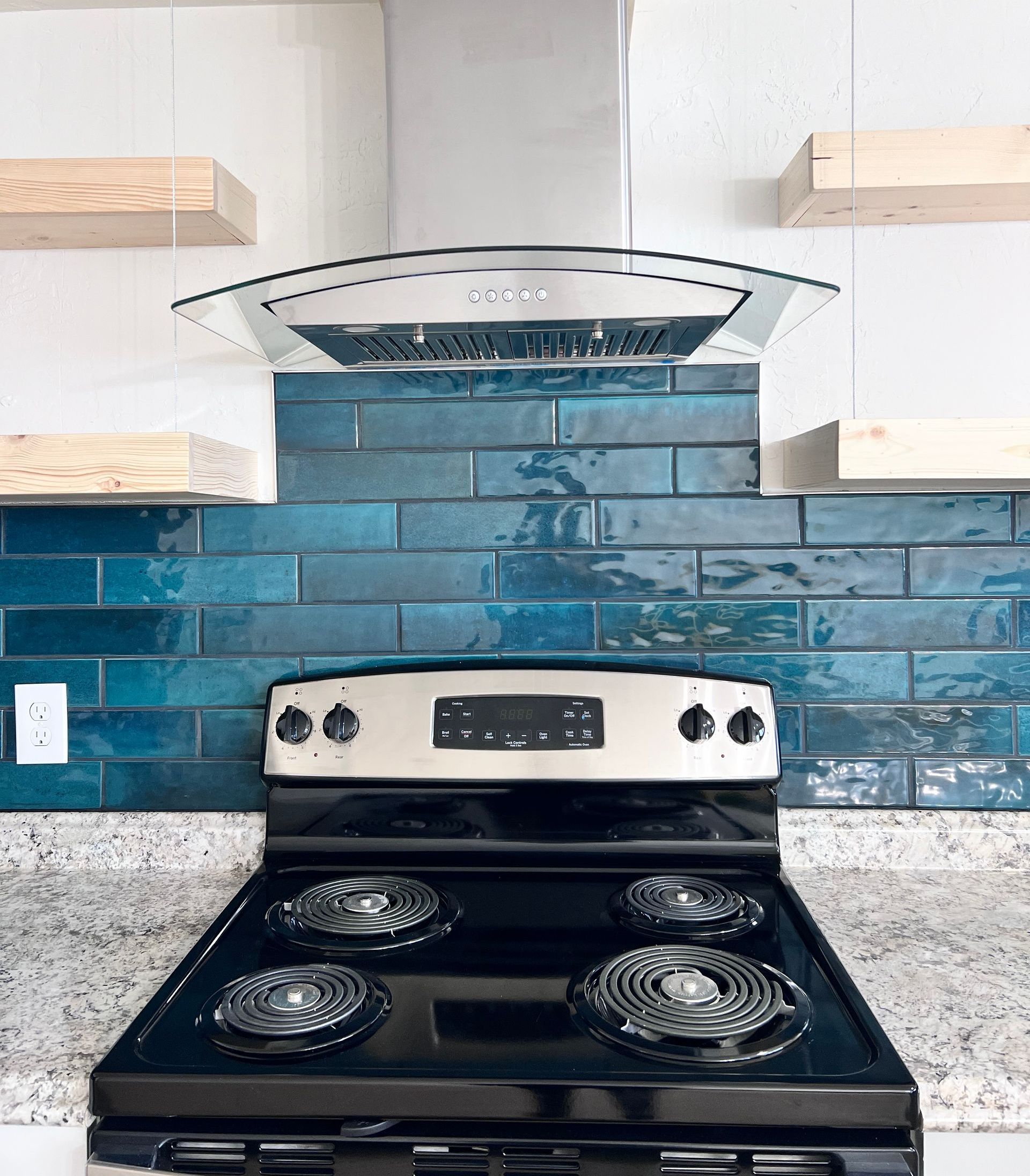 A black stove top oven with a hood above it in a kitchen.