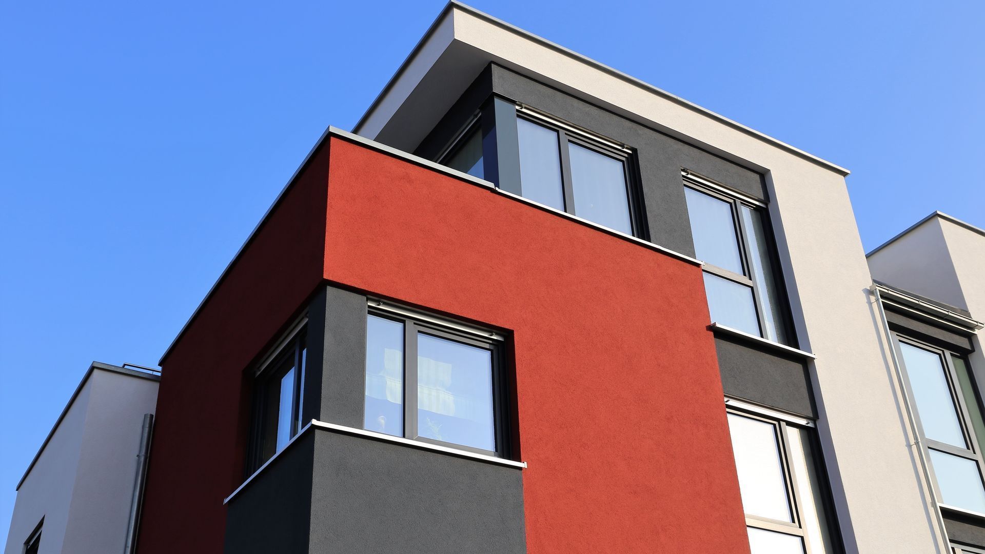 A red and black building with a blue sky in the background