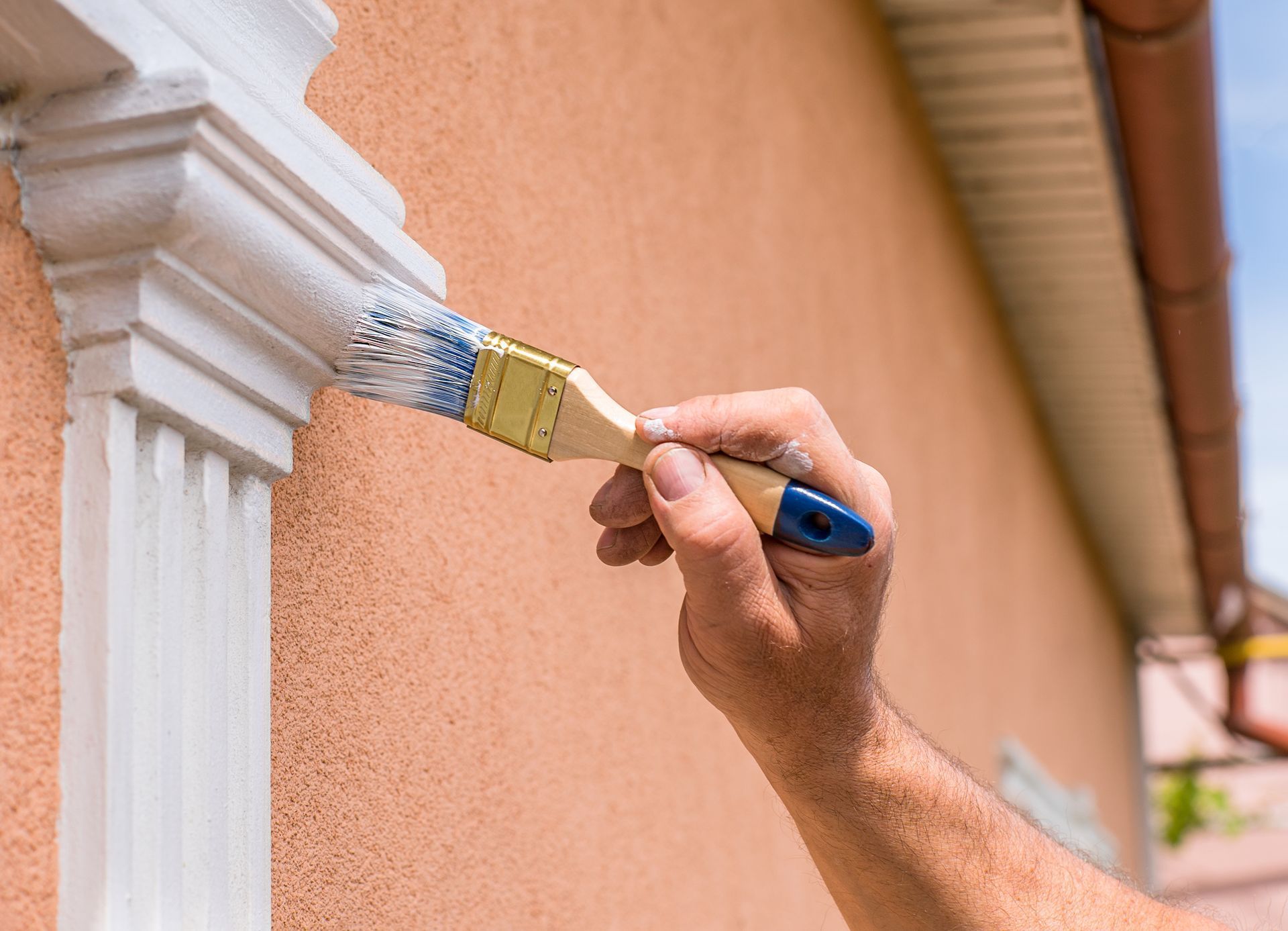 A person is painting a wall with a brush.