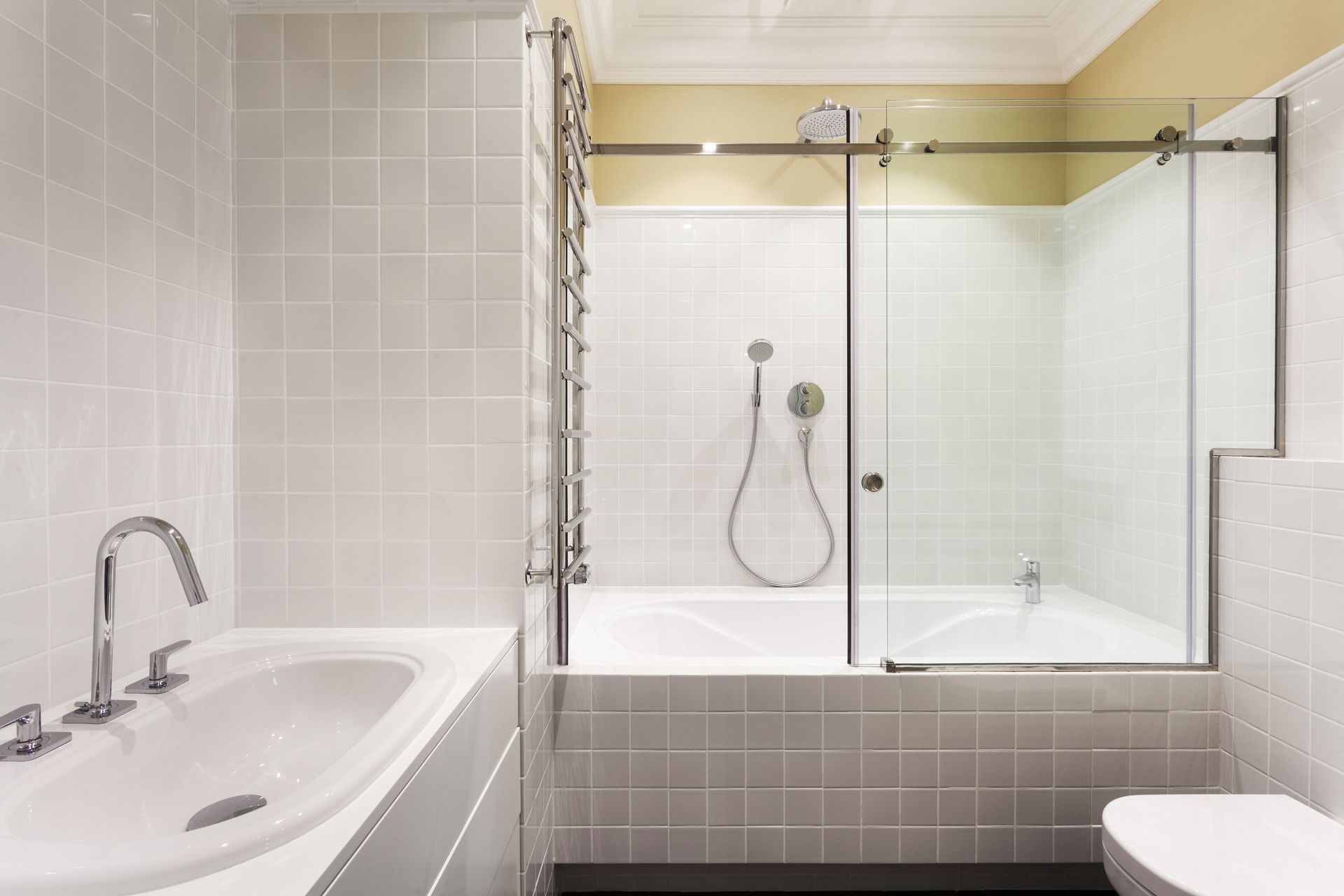 A bathroom with a bathtub , toilet , sink and shower.