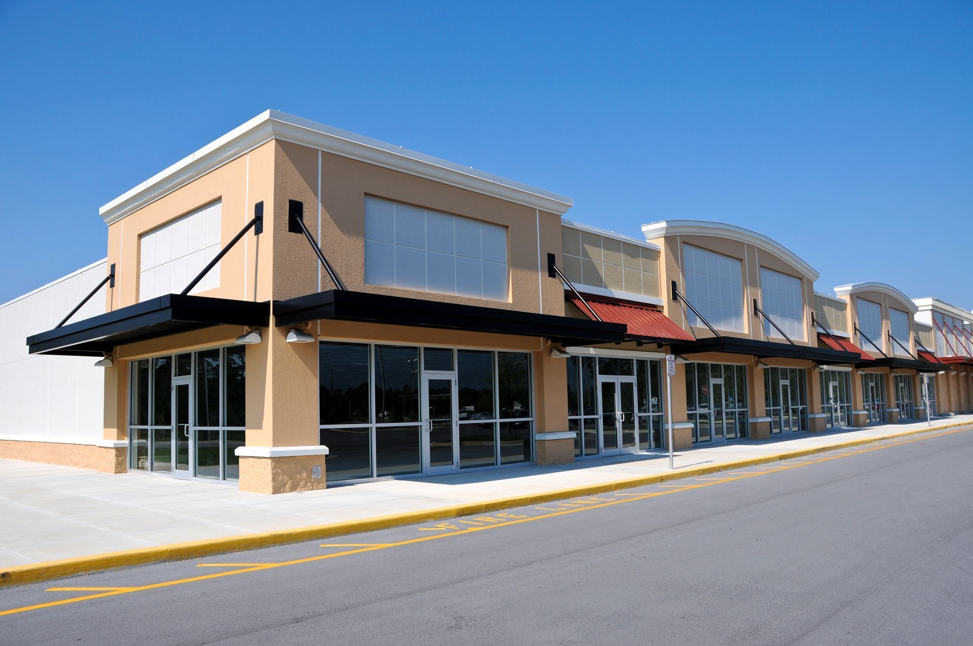 A row of empty stores with a blue sky in the background