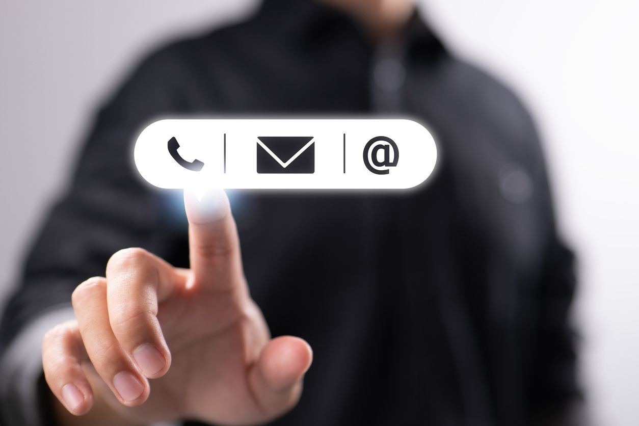 A businessman is seen pressing the icons for mail, phone, and address