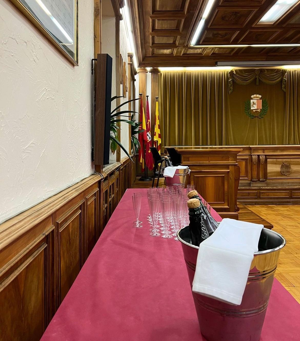 A table with a bucket of champagne and glasses on it