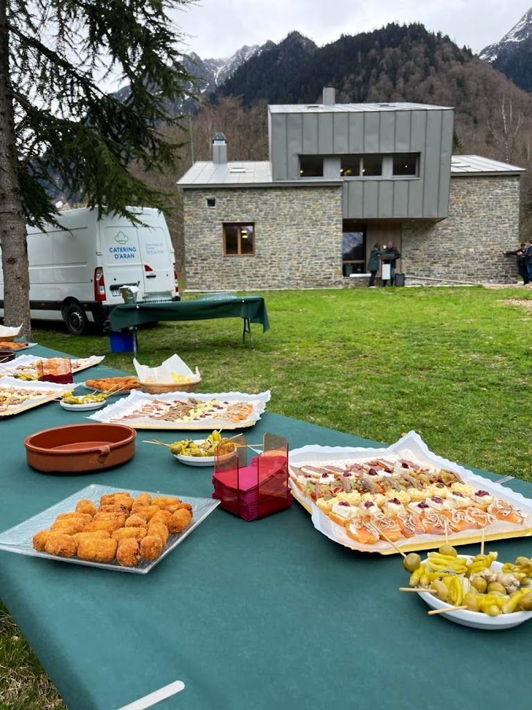 A table with plates of food on it in front of a house.