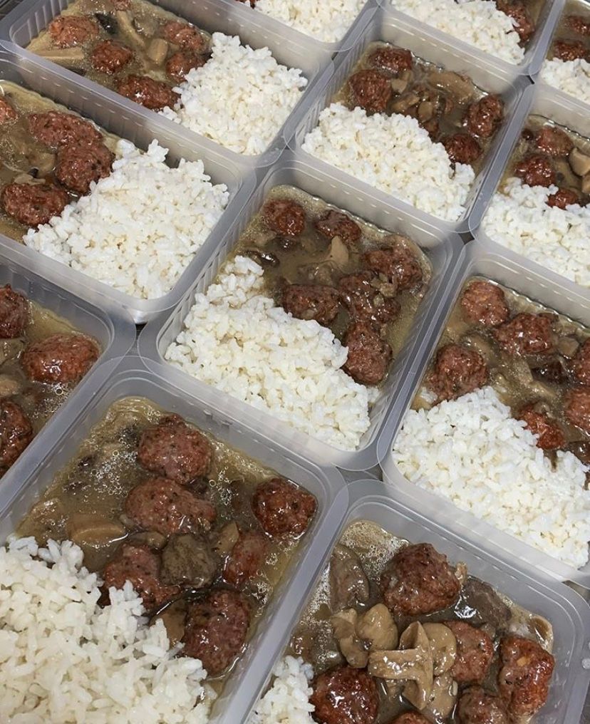 A bunch of containers filled with meatballs and rice