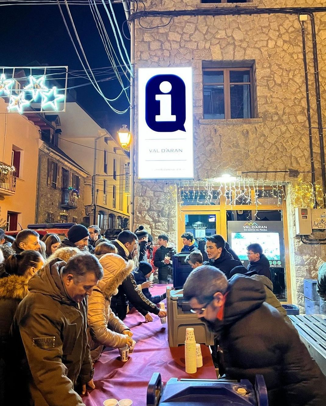 A group of people standing around a table in front of a sign that says i